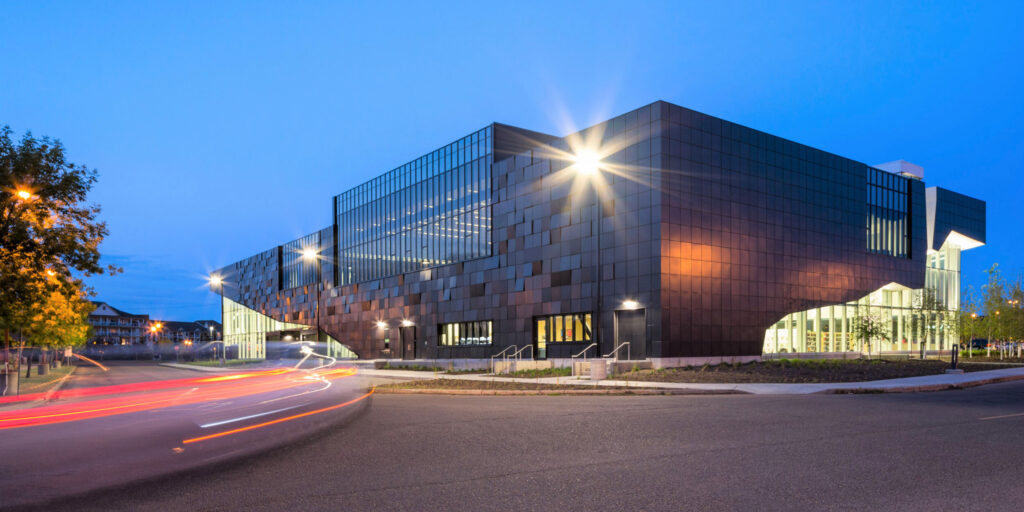 The Mill Woods library at night; a time-delay photo with traffic lights swirling along the road.