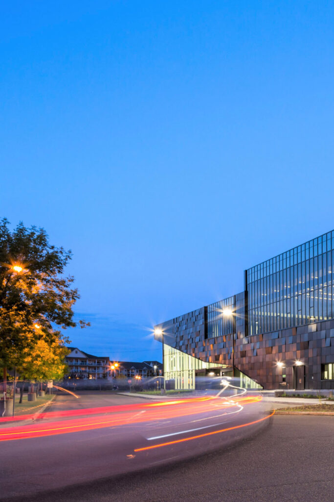 The Mill Woods library at night; a time-delay photo with traffic lights swirling along the road.