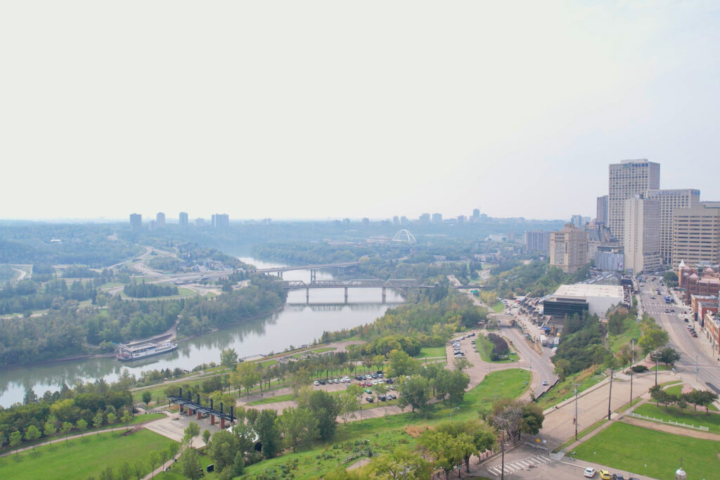 An aerial view of the Riverdale neighbourhood. The Telus building, the Edmonton Convention Centre and ATB Financial building are visible, with the North Saskatchewan River weaving in the foreground.