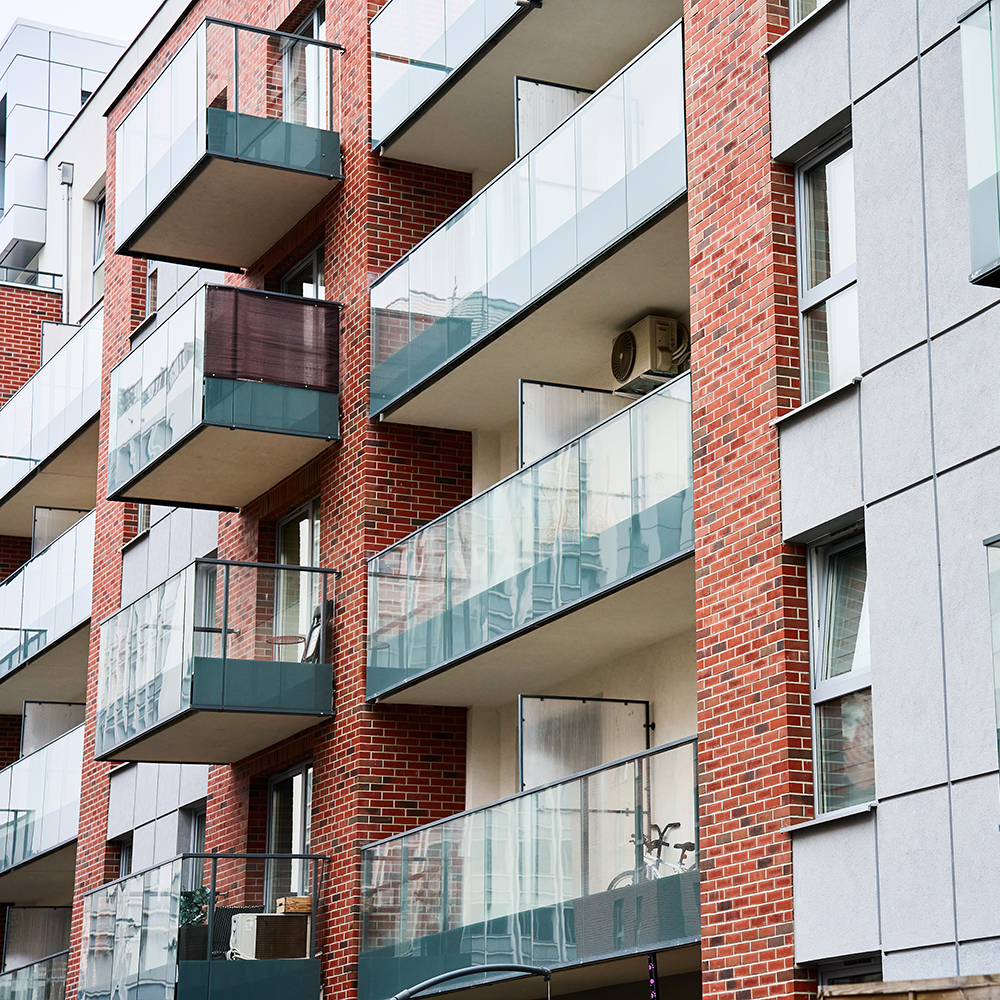 Residential building brick facade with balconies and windows.