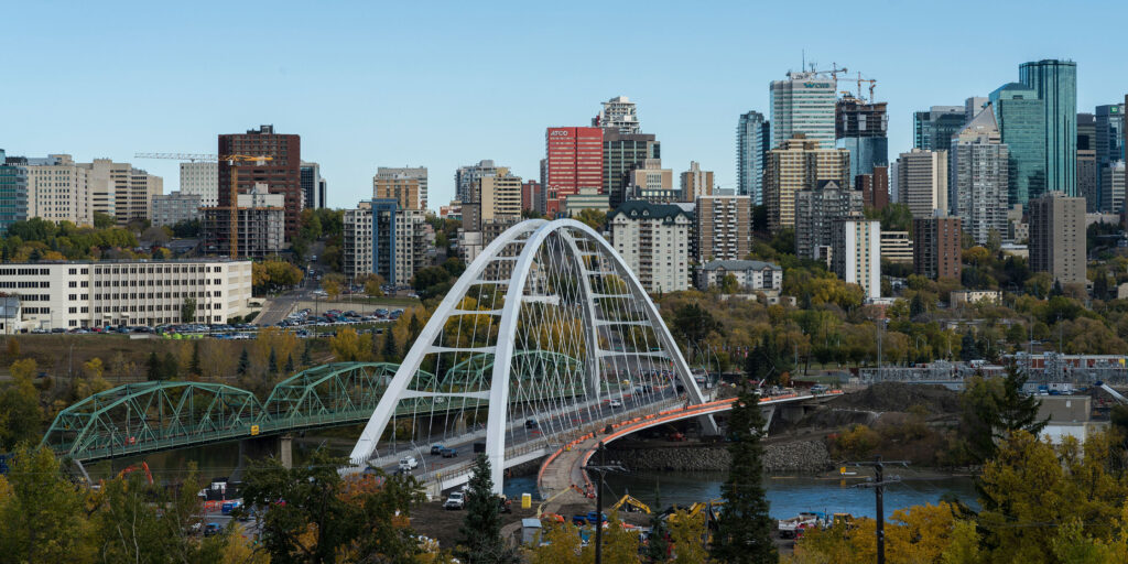 Birds eye view of Edmonton's river valley and downtown skyline. The Walterdale Bridge is in the foreground, reaching over the North Saskatchewan River.