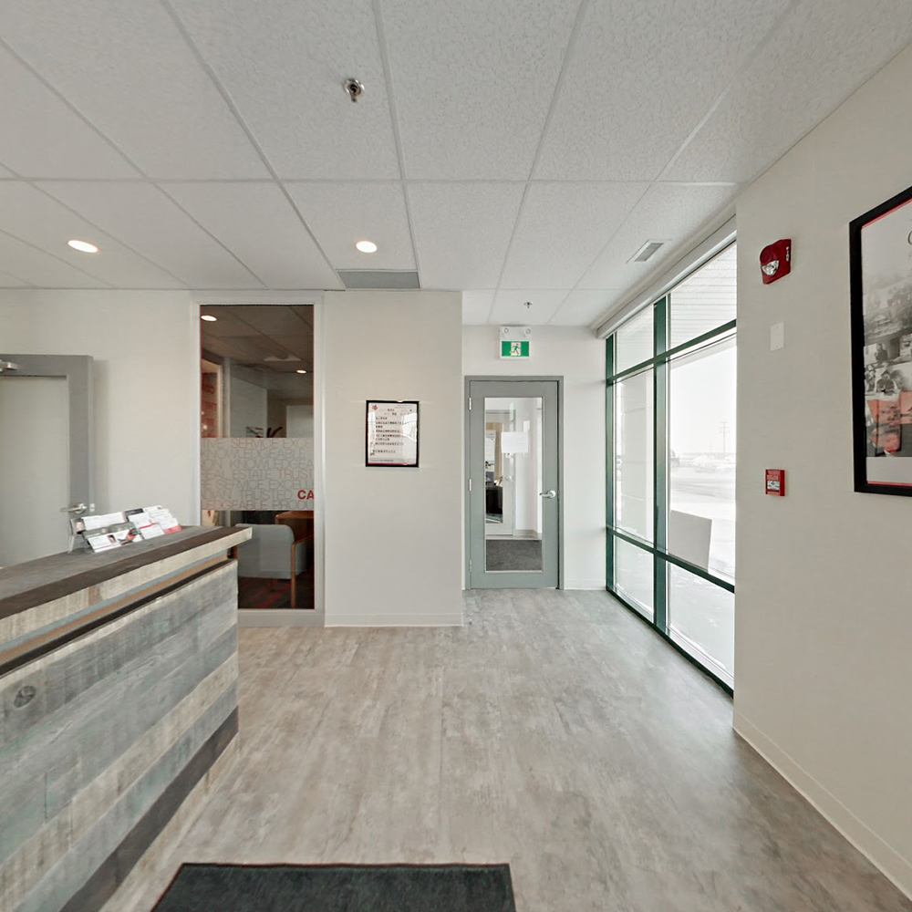 The lobby of the Sherwood Park office. The floors, desk and doors are various shades of grey and beige.