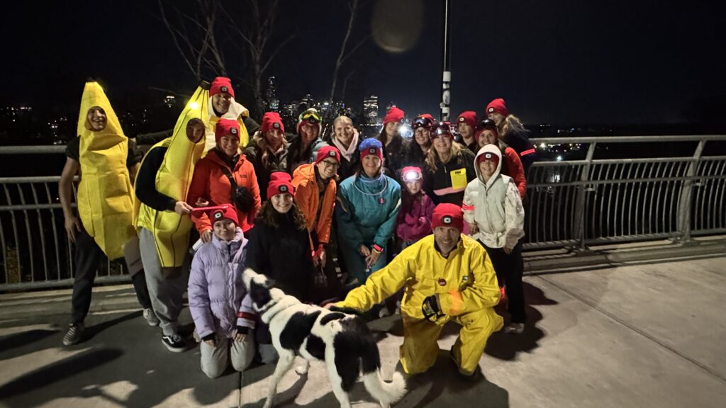 Team of participants in bright costumes posing on a bridge.
