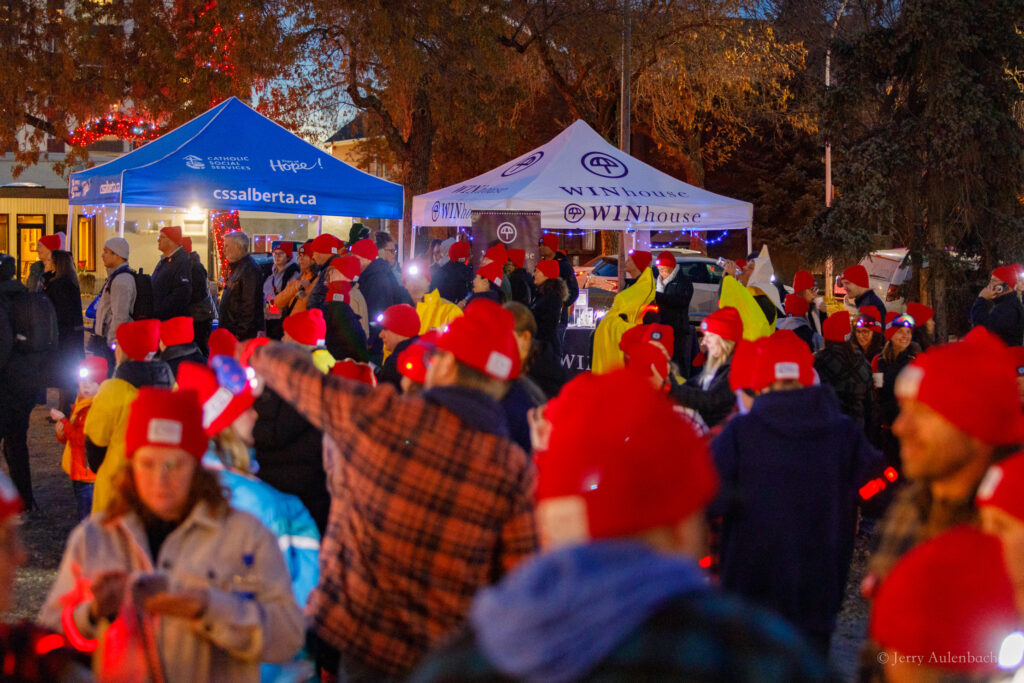 Crowd gathered near WIN House and Catholic Social Services tents before the walk.