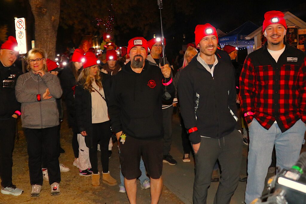 Participants wearing red toques smiling during the walk.