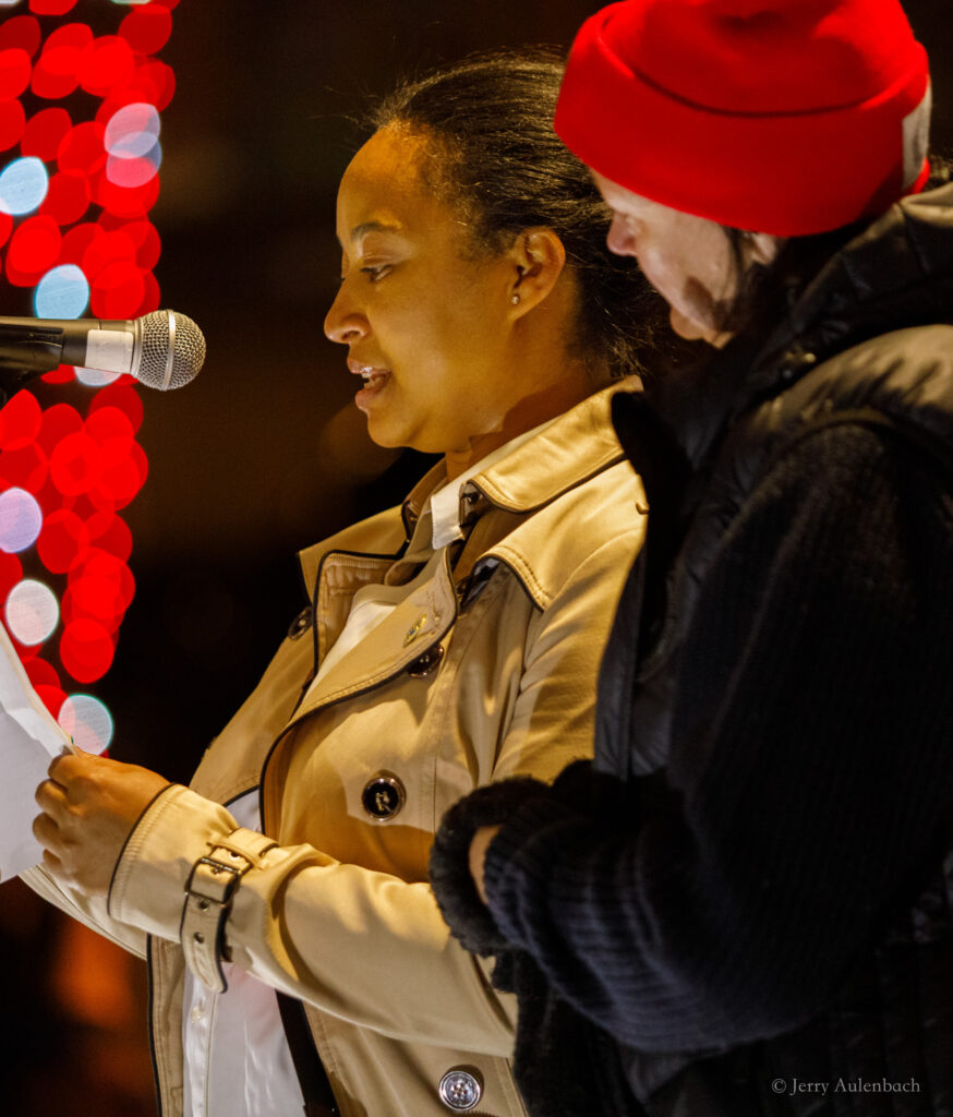 Speaker addressing the crowd at a podium under event lights.