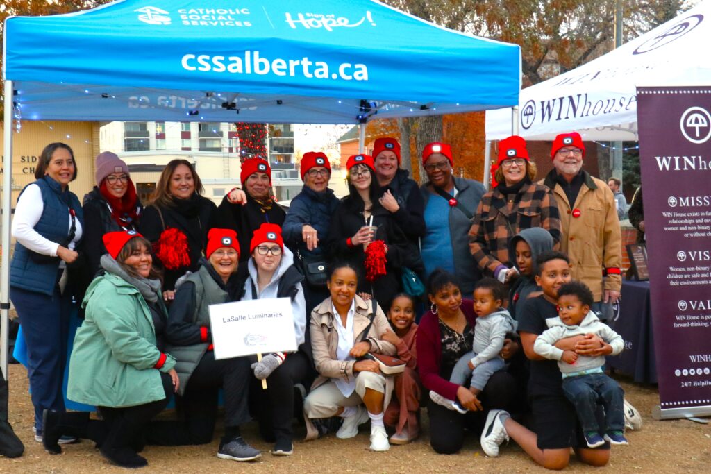 Team LaSalle Luminaries posing with Catholic Social Services and WIN House at their tents.