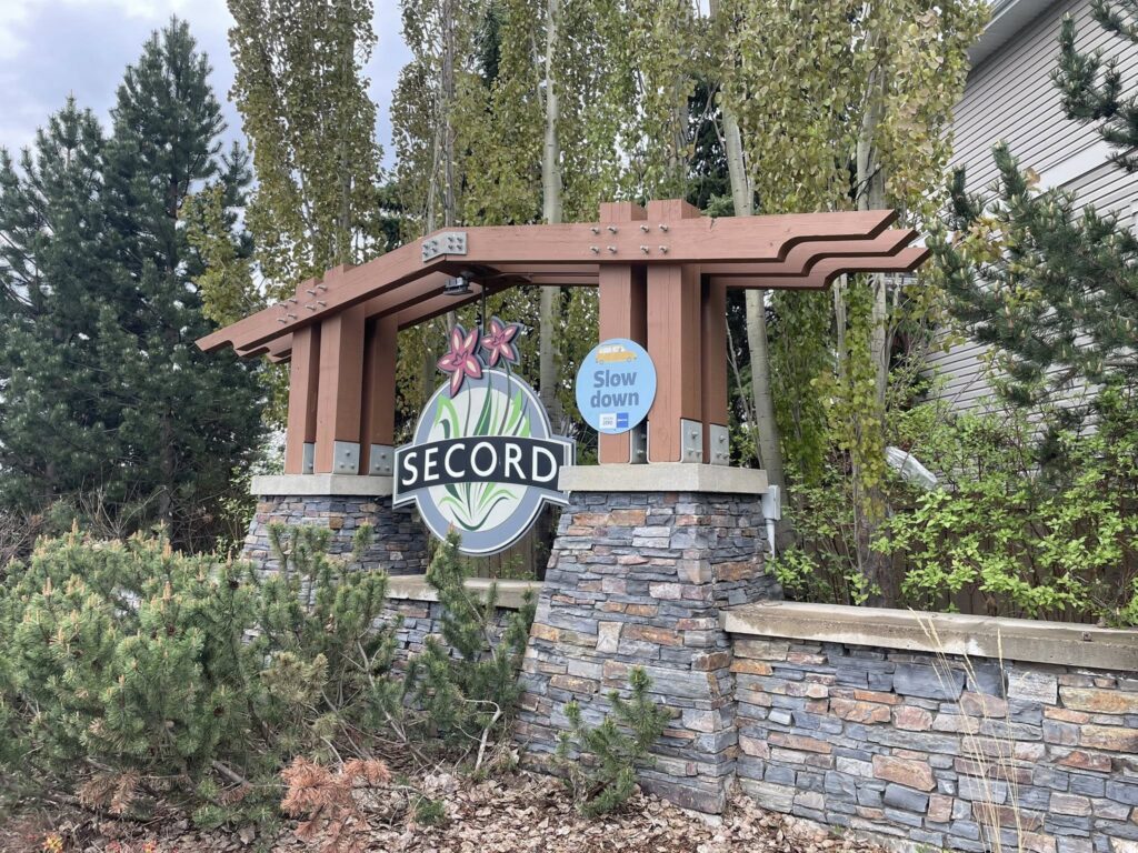 Secord West Edmonton neighbourhood signage and trees.