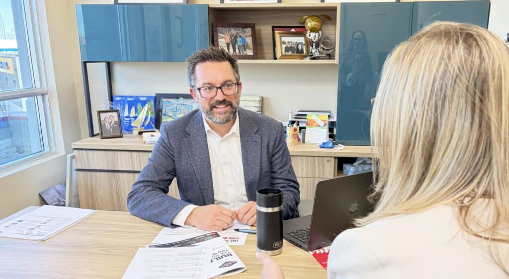 Tom Shearer meeting with a real estate agent to discuss business planning at Royal LePage Noralta Real Estate.
